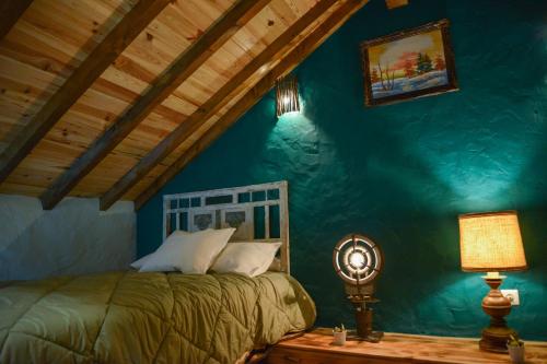 a bedroom with a bed and a blue wall at Casa do Ti João in Sabugueiro