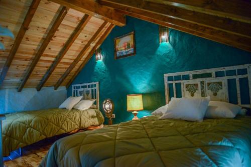 a bedroom with two beds and a blue wall at Casa do Ti João in Sabugueiro