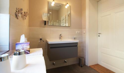 ein Bad mit einem Waschbecken und einem Spiegel in der Unterkunft Ferienwohnung Seeadler Nr. 8 in Kühlungsborn