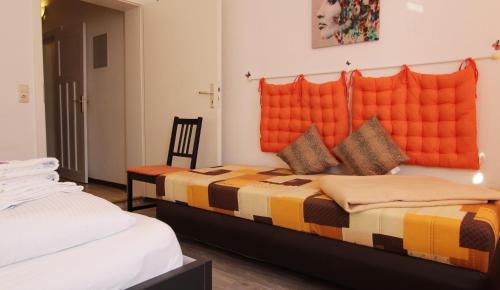 una camera con 2 letti e una coperta arancione di Ferienwohnung Familienwohnung a Kröpelin