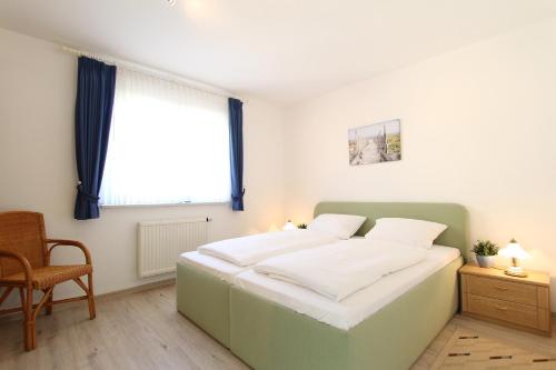 Schlafzimmer mit einem großen weißen Bett und einem Fenster in der Unterkunft Ferienwohnung Christine in Kühlungsborn