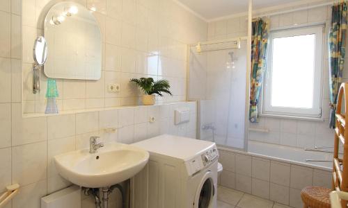 a bathroom with a sink and a washing machine at Ferienwohnung Christine in Kühlungsborn