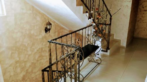 a staircase in a house with a wrought iron railing at Dracena Guesthouse in Ravda