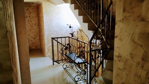 a spiral staircase in a building with a wrought iron railing at Dracena Guesthouse in Ravda