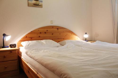 キュールングスボルンにあるFerienwohnung Grosse Krabbeのベッドルーム(白い大型ベッド1台、木製ヘッドボード付)