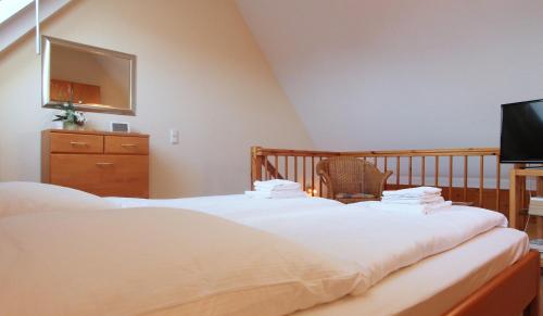 1 Schlafzimmer mit 2 Betten, einem TV und einem Kinderbett in der Unterkunft Ferienwohnung Parkblick Nr. 22 in Kühlungsborn