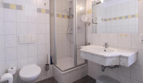 a bathroom with a sink and a shower and a toilet at Ferienwohnung Parkblick Nr. 22 in Kühlungsborn