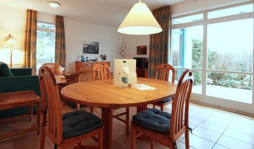 a dining room and living room with a wooden table and chairs at Ferienwohnung Warnke in Kühlungsborn