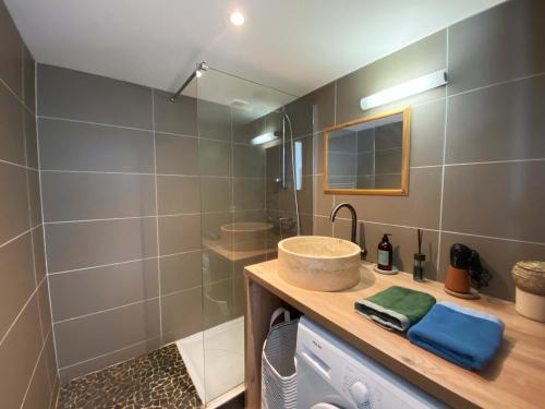 La salle de bains est pourvue d'un lavabo et d'une douche. dans l'établissement Studio et piscine sur la grande plage, à Biarritz