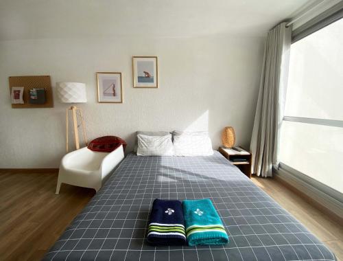 a bedroom with a bed with two pillows on it at Studio et piscine sur la grande plage in Biarritz