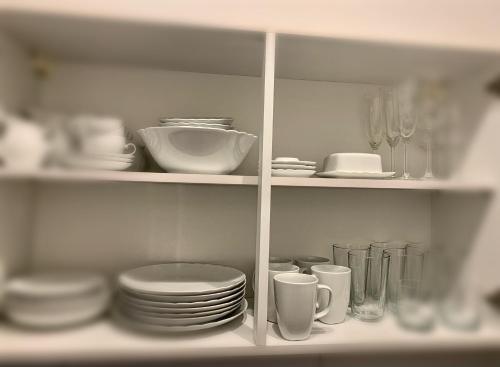 un estante lleno de platos y tazas en Apartments am Wasser by Fewo & Zimmer Bruns, en Emden
