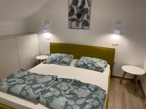 a bedroom with a bed and two tables in it at Apartma Lilija Golte in Mozirje