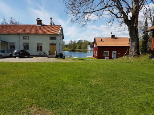 ein Haus und eine rote Scheune und ein See in der Unterkunft Lugnet i Oslättfors in Gävle