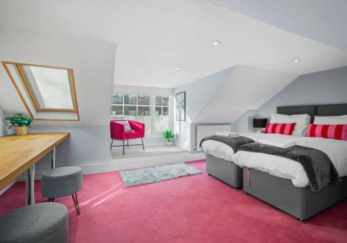 a bedroom with a bed and a desk and a red rug at The Townhouse By My Getaways Free Parking in Brighton & Hove