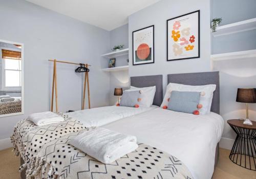 two beds in a bedroom with white and blue at The Townhouse By My Getaways Free Parking in Brighton & Hove