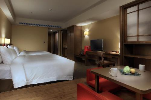 a hotel room with a large bed and a television at Fullon Hotel LihPao Resort in Houli