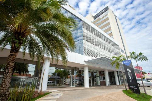 a palm tree in front of a building at Slaviero Rondonópolis Centro in Rondonópolis