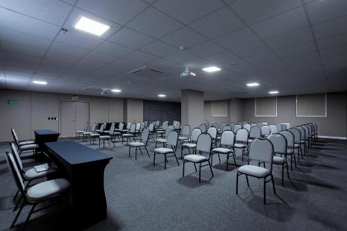 a room with rows of chairs and tables in a classroom at Slaviero Rondonópolis Centro in Rondonópolis