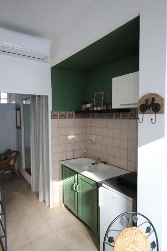 - une cuisine avec des placards verts et un mur vert dans l'établissement L'étape Bessièraine: Toulouse, Albi et Montauban, à Bessières