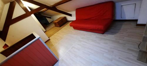 a room with a red couch in a attic at LE LAMPEDUSA in Maninghem