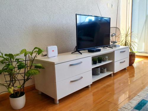 Dalija Apartment في بيهاتش: تلفزيون في خزانة بيضاء في غرفة المعيشة