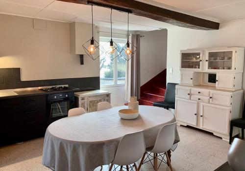 a kitchen with a table and chairs in a room at Maison Spacieuse à Boulieu in Courtenay