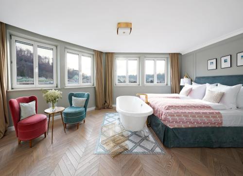 ザルツブルクにあるnuma l Mozartのベッドとバスタブ付きのホテルルームです。