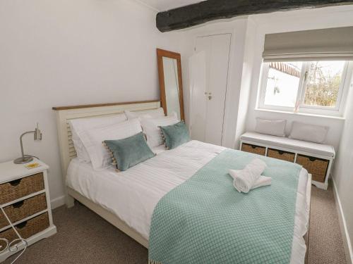 um quarto com uma grande cama branca com almofadas azuis em Ty Coed em Beaumaris