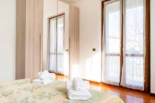バスティーア・ウンブラにあるCasa del Giardino Bright Apartmentのベッドルーム1室(窓のあるベッドに白いタオル2枚付)