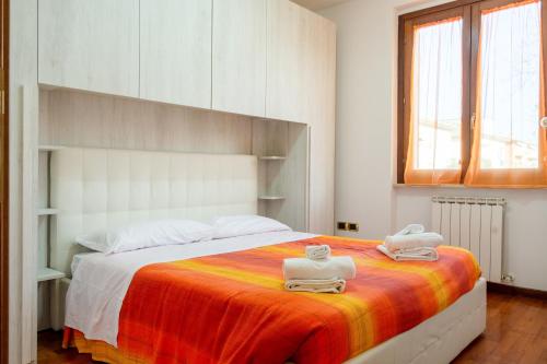 a bedroom with a large bed with two towels on it at Casa del Giardino Bright Apartment in Bastia Umbra