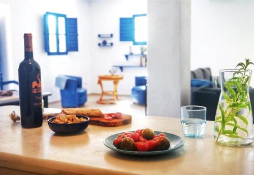 a table with a bottle of wine and a plate of fruit at Algarrobo Azul in Almuñécar