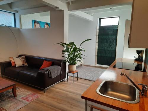 uma sala de estar com um sofá e um lavatório em Bed & Breakfast Oude Bakkerij em Rijswijk