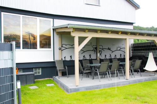 a patio with chairs and a table on the side of a house at Gästehaus Mittendrin in Dahn