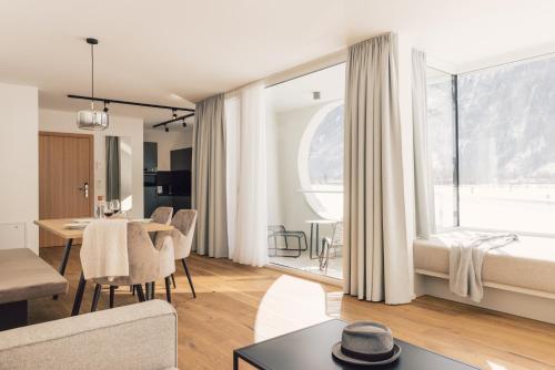 - un salon avec une table et une salle à manger dans l'établissement Sima-Apartments, à Längenfeld