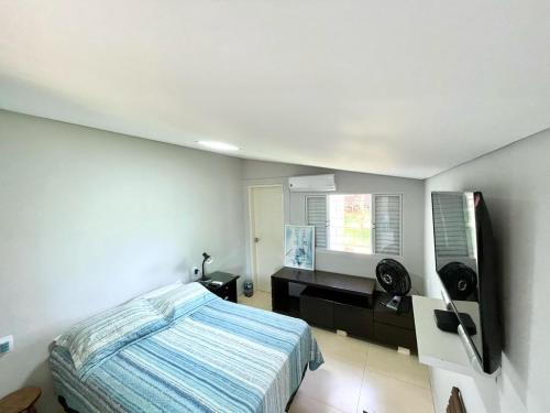 Un dormitorio con una cama y un escritorio y una ventana. en Suite Confortavel em Chapada dos Guimaraes, en Chapada dos Guimarães