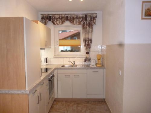 a white kitchen with a sink and a window at Apart Alblittblick in Kappl