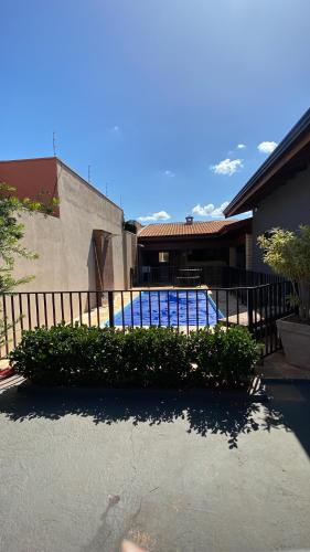 une maison avec une clôture et une piscine dans l'établissement Casa de temporada Amelio Dionísio, à Olímpia