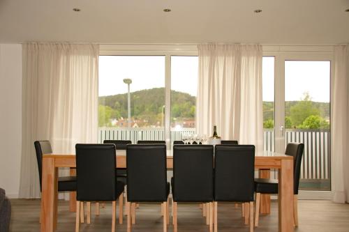 a dining room with a table and black chairs at Gästehaus Mittendrin in Dahn