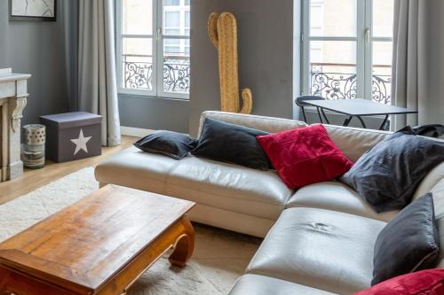 een woonkamer met een bank en een salontafel bij Contemporary Furnished Duplex With 3 Bedrooms Near All Amenities in Bordeaux