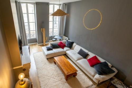 een woonkamer met een bank en een tafel bij Contemporary Furnished Duplex With 3 Bedrooms Near All Amenities in Bordeaux
