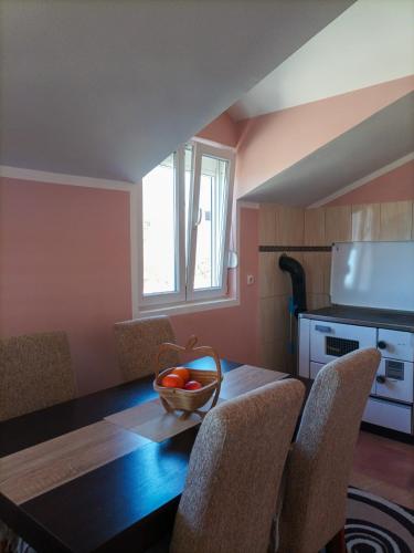 a dining room table with chairs and a bowl of fruit on it at Apartman Balsa in Kotor