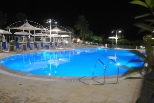 a large swimming pool at night with chairs and umbrellas at Edra Palace Hotel & Ristorante in Cassino