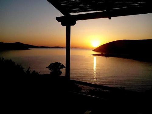 a sunset over a body of water with the sun setting at Alezina studios in Amorgos