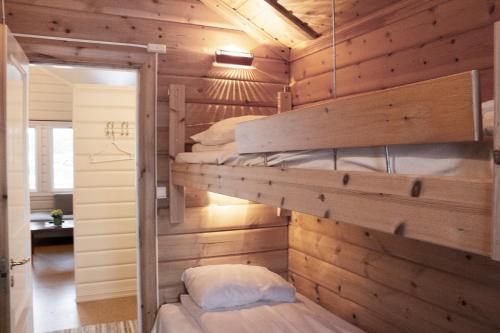 a bedroom with two bunk beds in a wooden wall at Topcamp Havblikk - Helgeland in Nesna