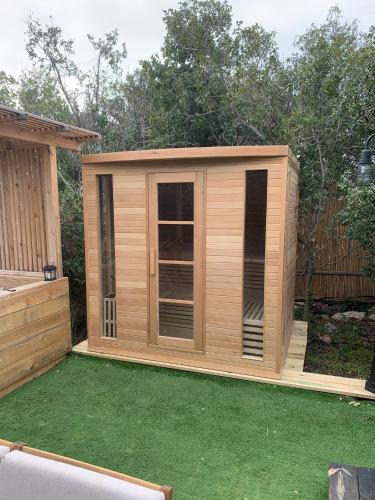 a small wooden shed with a lawn at בקתות בית מאיר אבירים - זמן בריאה in Abirim