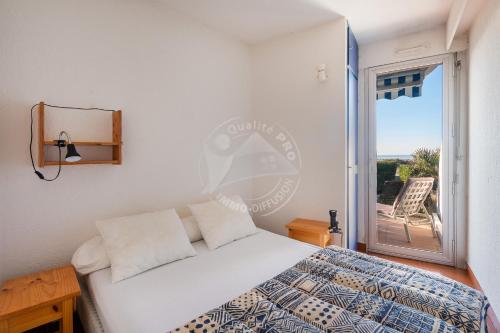 um quarto com uma cama e uma varanda em AS8313 - P2 cabine avec parking privé, accès direct à la plage em Le Grau-du-Roi