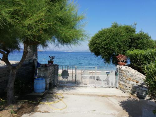 a gate with a tree and the ocean in the background at Oneiro in Diliso