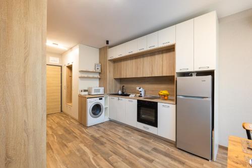 a kitchen with white cabinets and a washer and dryer at Helena Holiday A in St. St. Constantine and Helena