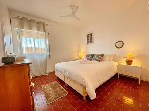 een slaapkamer met een wit bed en een raam bij Ria Beach House in Faro
