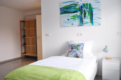 1 dormitorio con 1 cama y una pintura en la pared en N37 -modern eingerichtete Zimmer in ruhiger Lage, en Aldingen